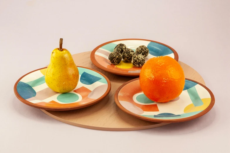 a couple of plates that have fruit on them, a still life, inspired by Sarah Morris, trending on dribble, orange and teal, terracotta, high quality product photo, moroccan