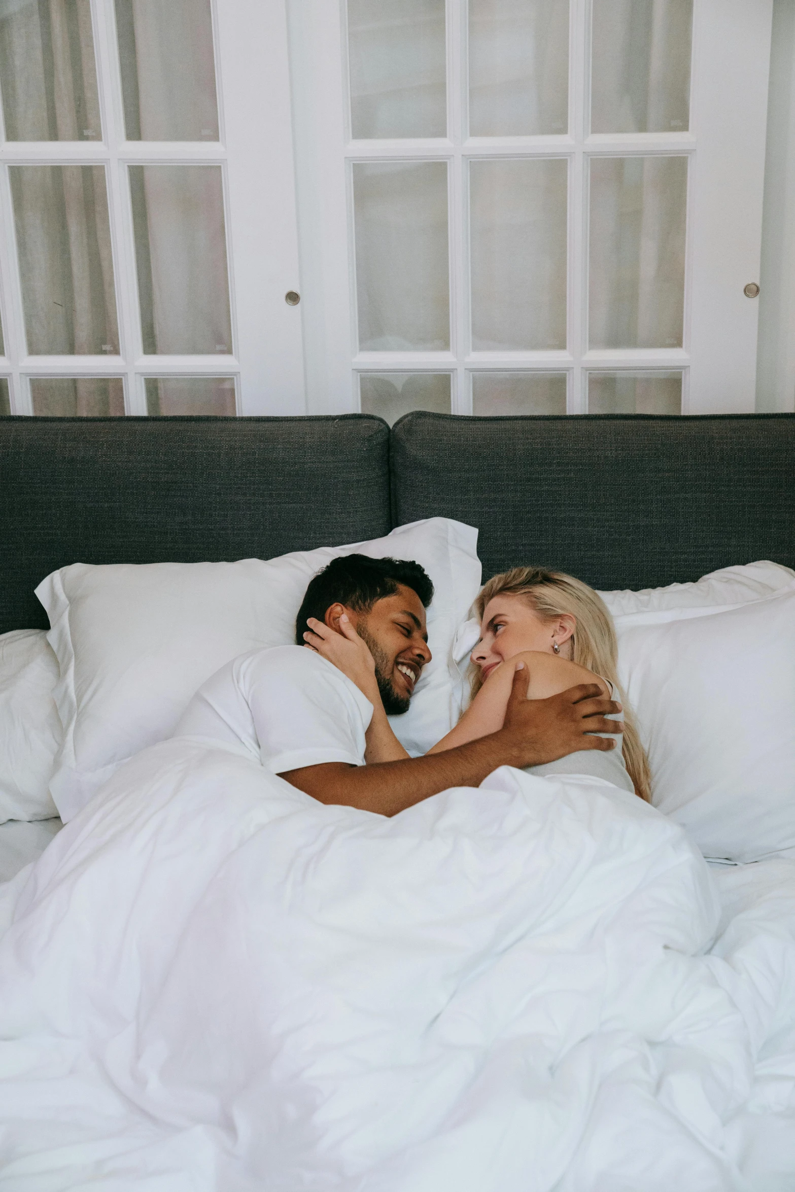 a man and woman laying in bed next to each other, sydney hanson, the best, covered, comfy