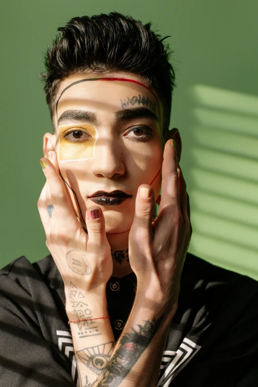 a man with his hands on his face, an album cover, inspired by Hedi Xandt, trending on pexels, an epic non - binary model, facepaint, teenage boy, enes dirig