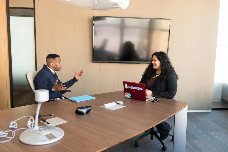 a couple of people that are sitting at a table, in a meeting room, jayison devadas, riyahd cassiem, vp of marketing