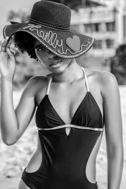 a woman in a swimsuit and hat on the beach, a black and white photo, by Lily Delissa Joseph, afro hair, trending photo, beutiful, attractive photo