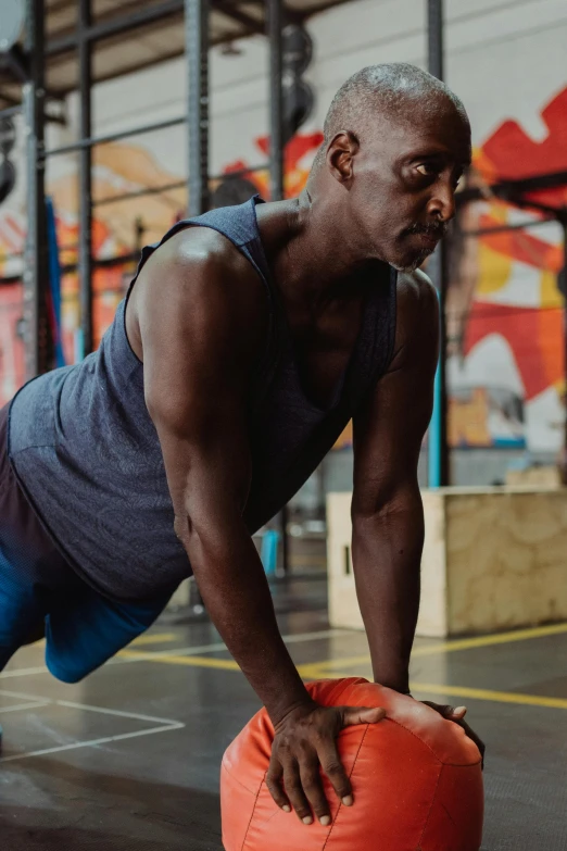 a man doing push ups with a medicine ball, a portrait, pexels contest winner, hyperrealism, emmanuel shiru, in a gym, promo image, lachlan bailey