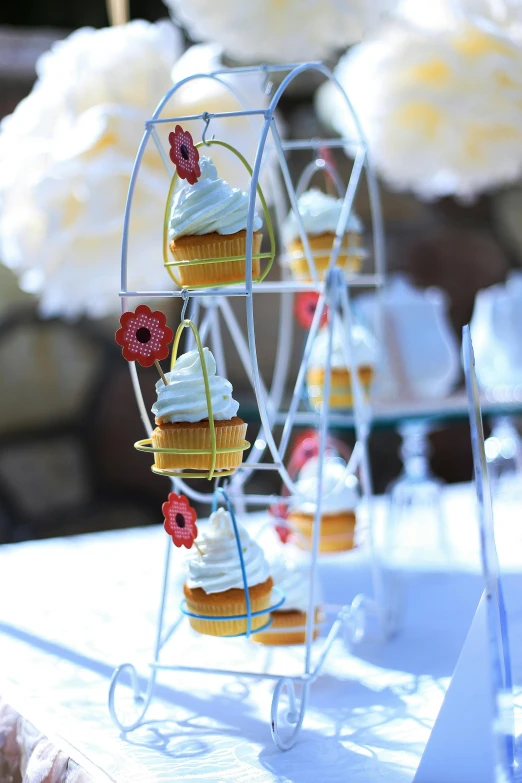 a table topped with cupcakes and a ferris wheel, upclose, up-close, afternoon time, featured