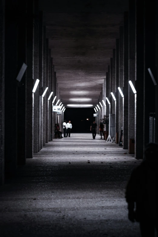 a man riding a bike down a dark hallway, unsplash contest winner, brutalism, lamps on ground, in the middle of an arena, dark people discussing, in a row