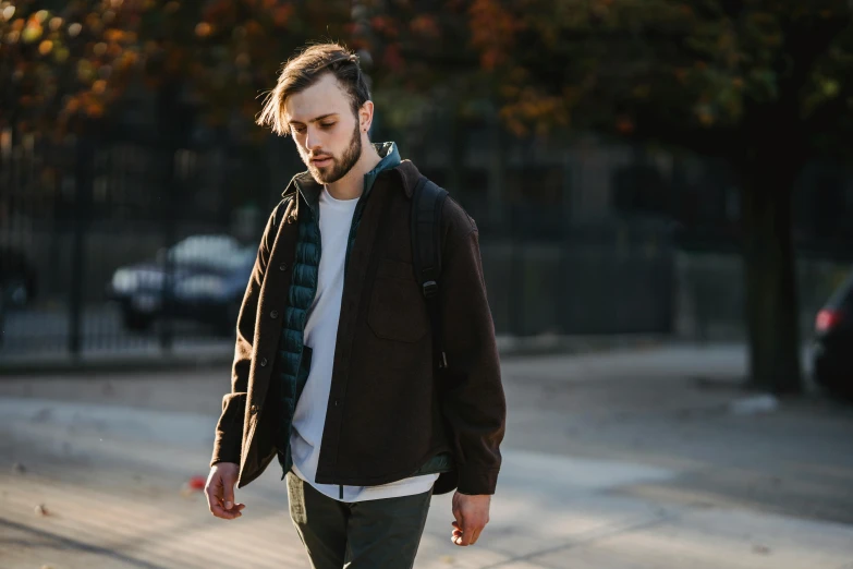 a man riding a skateboard down a street, a picture, by Niko Henrichon, unsplash, renaissance, brown jacket, sideburns, model is wearing techtical vest, lumberjack