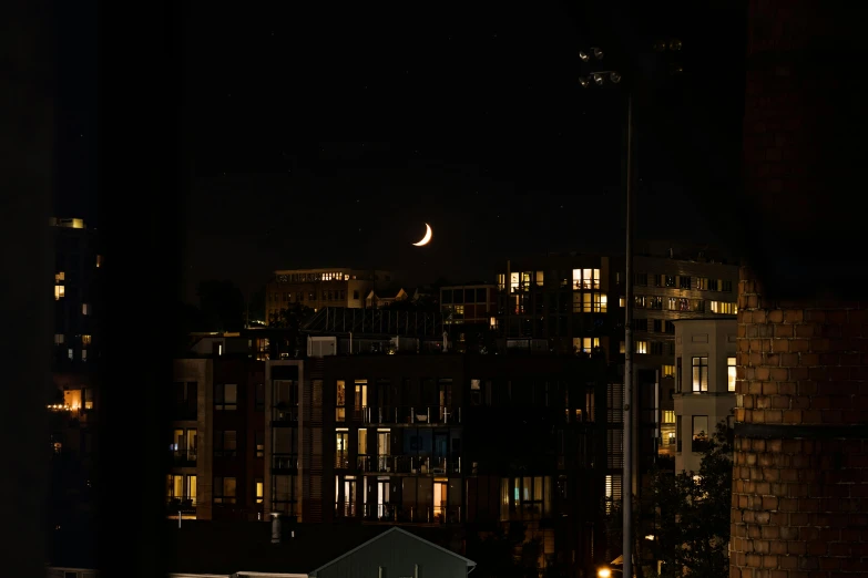 a view of a city at night from a window, a picture, by Jan Tengnagel, pexels contest winner, hurufiyya, crescent moon, amsterdam, 300mm, late summer evening