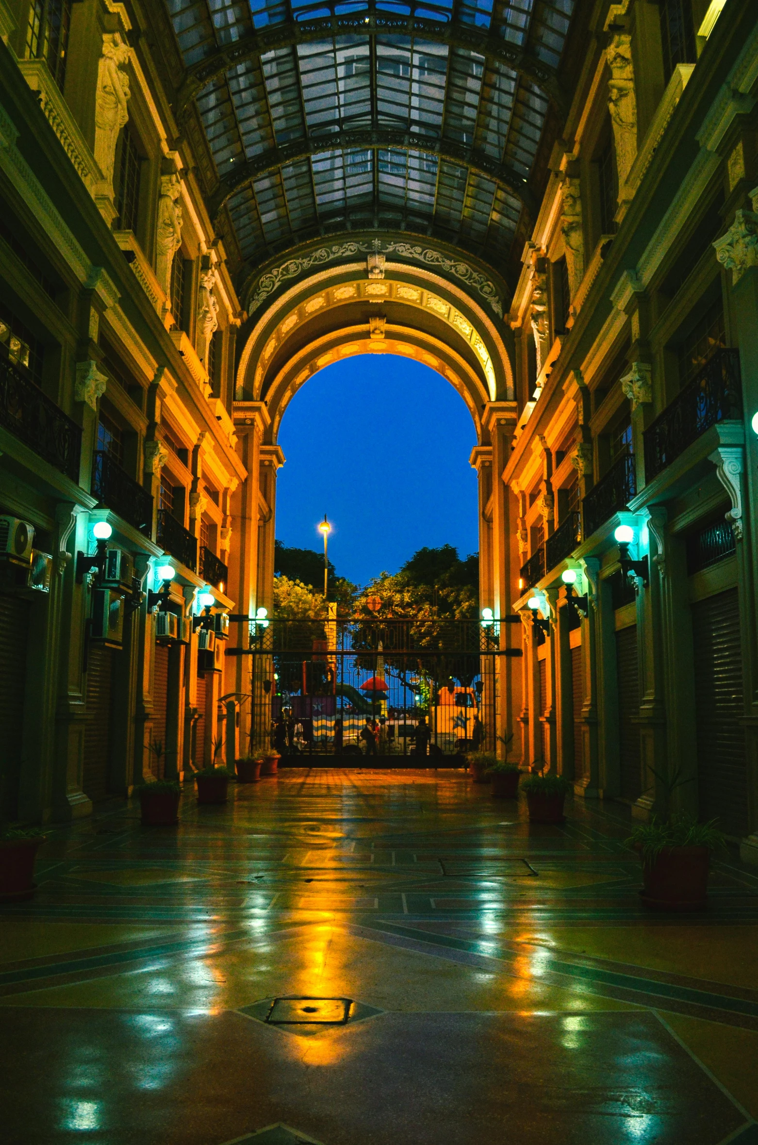 the inside of a building lit up at night, inspired by Luis Paret y Alcazar, pexels contest winner, neoclassicism, mall background, arch, chile, green alleys