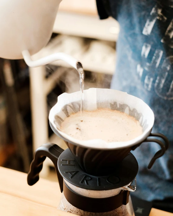 a close up of a person pouring a cup of coffee, by Carey Morris, hurufiyya, ceramic base, bib bang, very hazy, thumbnail