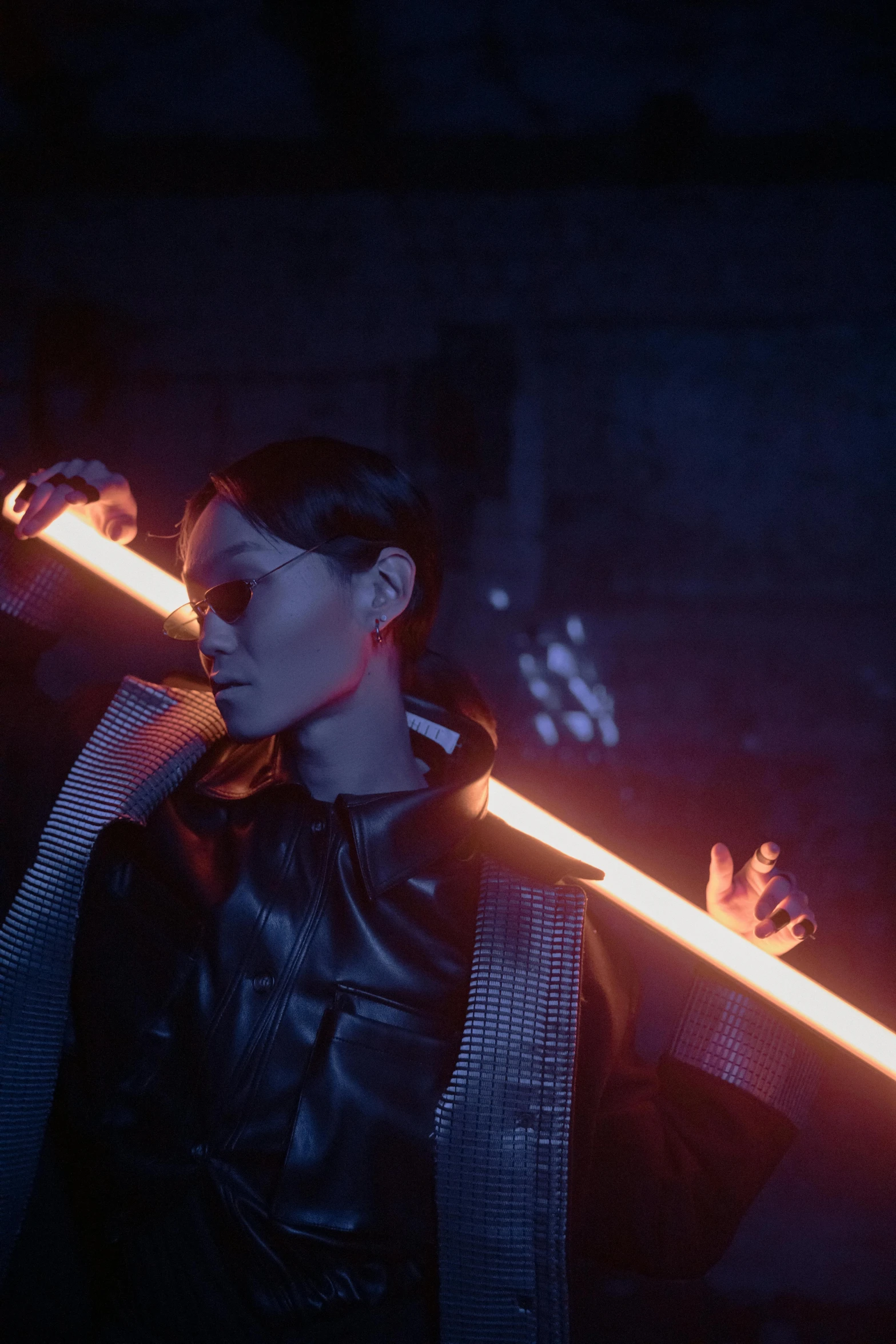 a man holding a light saber in a dark room, an album cover, inspired by Zhu Da, she has fire powers, futuristic sunglasses, many scars. cinematic lighting, holding a long sword | divine