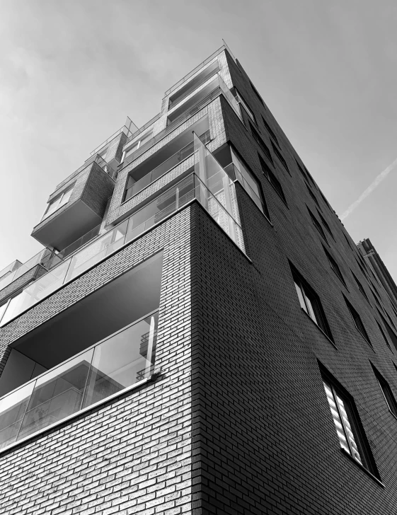 a black and white photo of a tall building, a black and white photo, unsplash, brutalism, low dutch angle, brick building, shot on iphone 1 3 pro max, monochrome 3 d model
