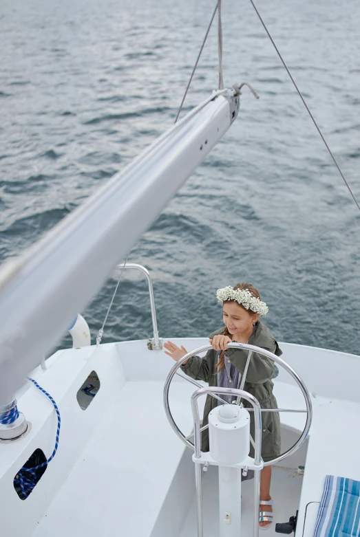 a woman sitting at the helm of a sailboat, by Liza Donnelly, happening, wearing a flower headpiece, high angle shot, on ocean, wearing a light grey crown