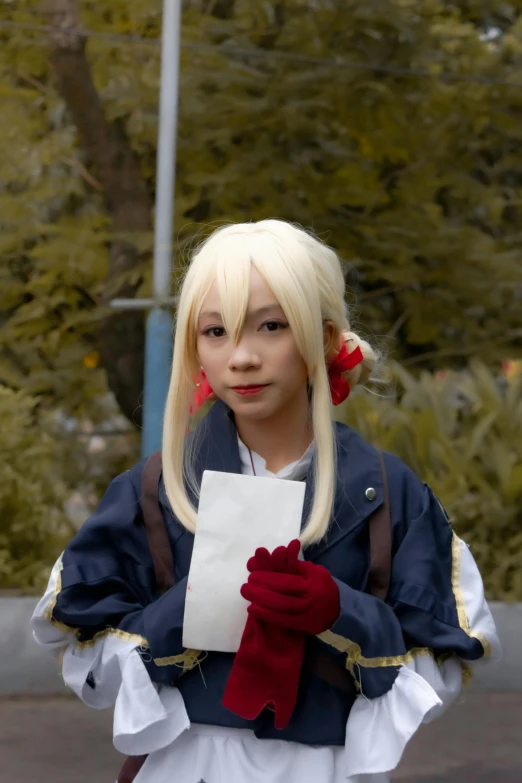 a woman in a cosplay costume holding a piece of paper, by Sengai, reddit, square, high quality photo, man?, blond