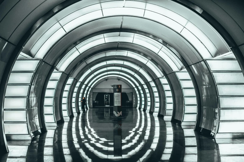 a black and white photo of a subway station, inspired by Zaha Hadid, unsplash contest winner, water reflection on the floor, symmetric lights, an archway, moscow metro