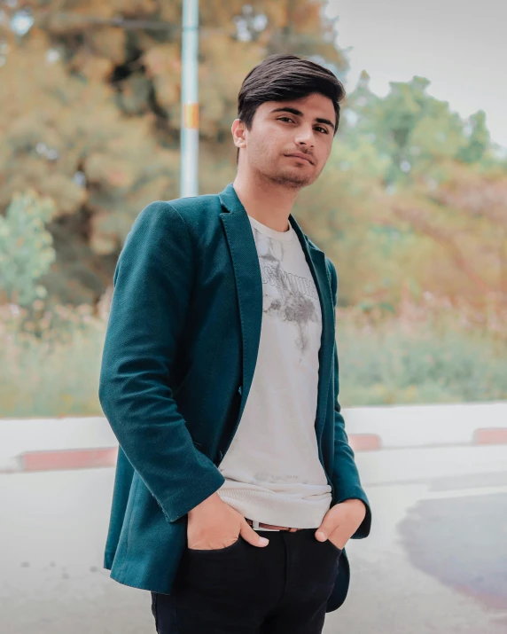 a man standing on a street with his hands in his pockets, an album cover, by Ismail Acar, pexels contest winner, wearing green jacket, he is about 20 years old | short, elegant profile pose, profile picture 1024px