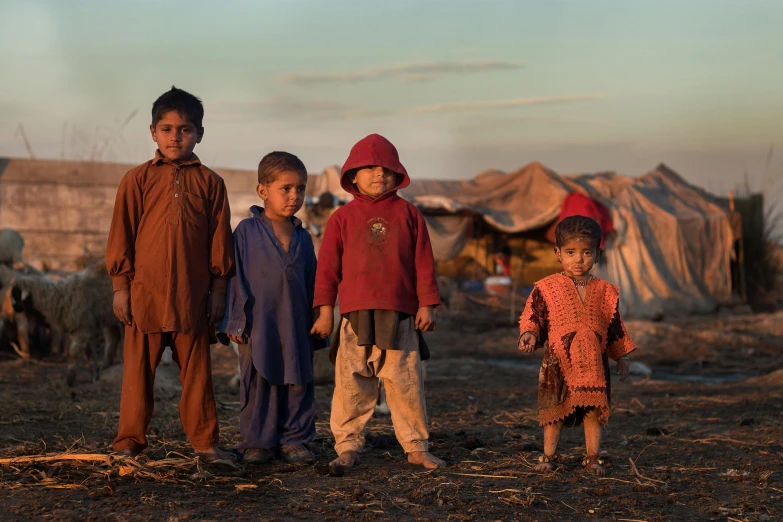 a group of children standing next to each other, by Dietmar Damerau, pexels contest winner, hurufiyya, an afghan male type, warm glow, devastation, settlement