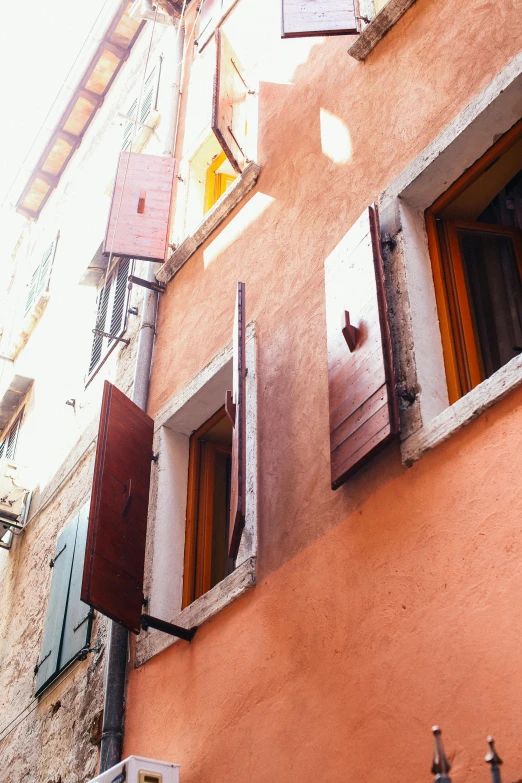 a building with shutters open on a sunny day, inspired by Quirizio di Giovanni da Murano, unsplash, renaissance, very warm colors, portholes, square, 1960s color photograph