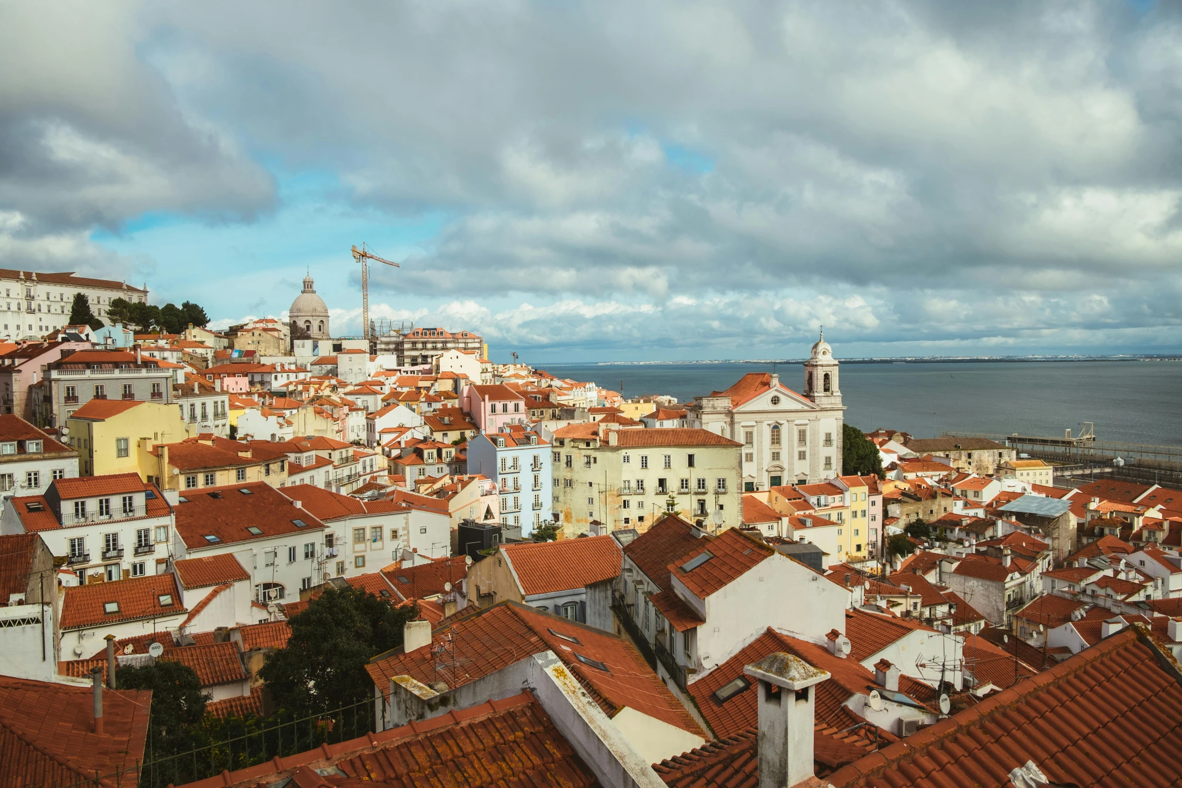 a view of a city from the top of a building, inspired by Almada Negreiros, pexels contest winner, renaissance, tiled roofs, seaside, frank gehry, profile image