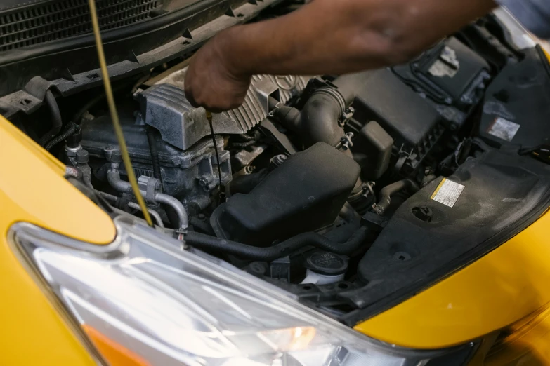 a man is working on a car engine, pexels contest winner, renaissance, black and yellow scheme, detail and care, 15081959 21121991 01012000 4k, tiny details