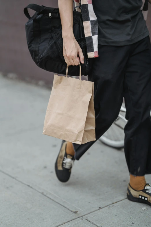 a man walking down a sidewalk while talking on a cell phone, an album cover, by Niko Henrichon, pexels contest winner, renaissance, shopping groceries, brown paper, loosely cropped, non-binary