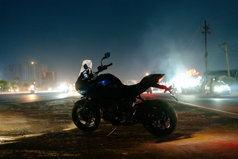 a motorcycle parked on the side of the road at night, profile image, fan favorite, extremely moody blue lighting, festivals