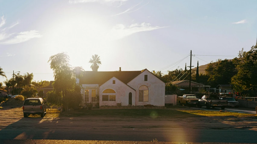 a house with a car parked in front of it, by Carey Morris, unsplash, late afternoon sun, southern california, sun puddle, an abandoned