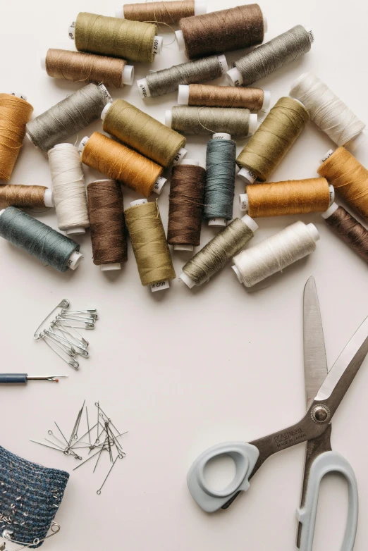 a bunch of spools of thread and a pair of scissors, trending on pexels, arts and crafts movement, 9 9 designs, thumbnail, earthy, costume design made with love