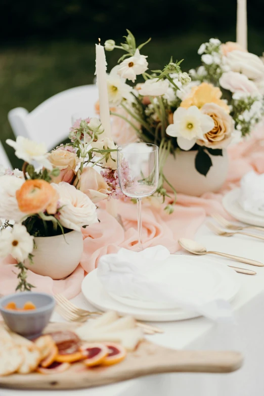 a table that has a bunch of food on it, unsplash, romanticism, pink orange flowers, tonal colors outdoor, elegantly dressed, cream and white color scheme