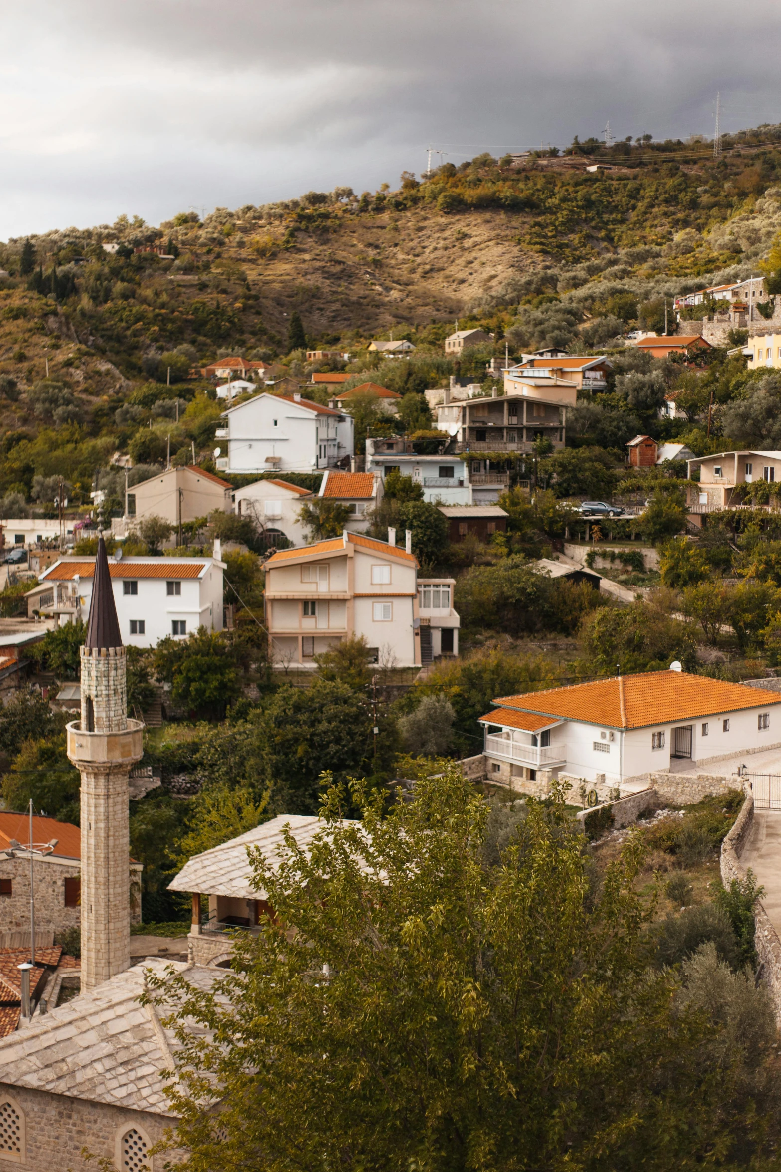 a view of a town from the top of a hill, by Daren Bader, split near the left, pilgrim village setting, mosque, beige