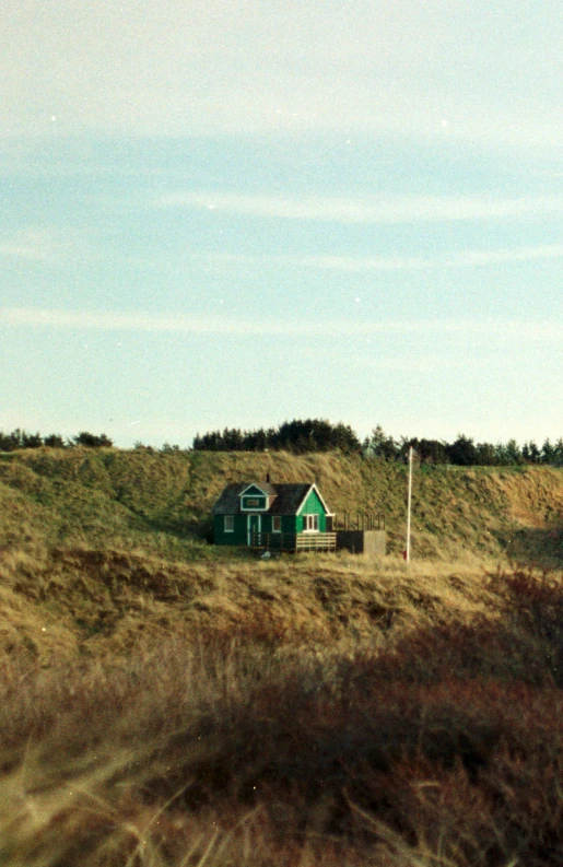 a green house sitting on top of a hill, by Christen Dalsgaard, flickr, on dune, in 1 9 9 5, shoreline, tiny house