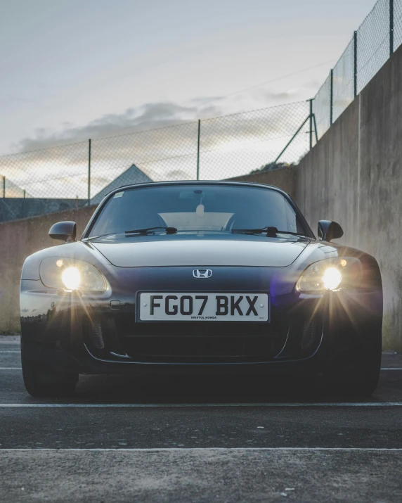 a black sports car parked in a parking lot, by John Henderson, unsplash, very round headlights, honda nsx, low quality photo, full pov