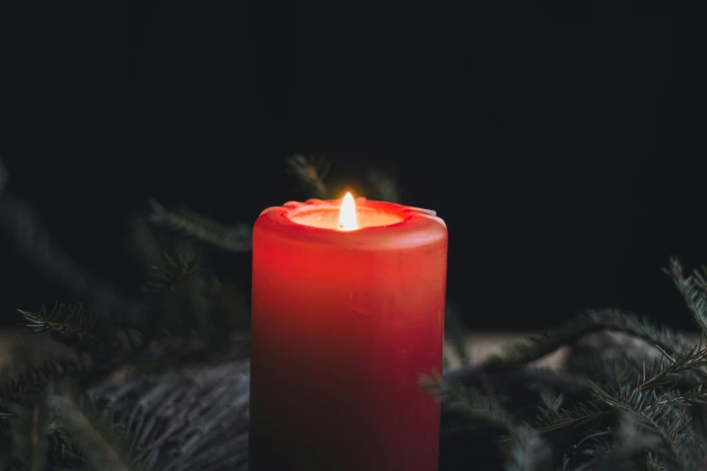 a red candle sitting on top of a wooden table, by Daniel Lieske, pexels contest winner, hurufiyya, red ribbon, made of glowing wax, on a gray background, christmas night