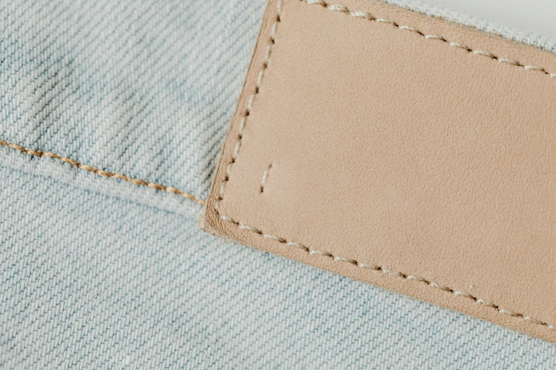 a label on the back of a pair of jeans, trending on pexels, light tan, plush leather pad, dezeen, product view