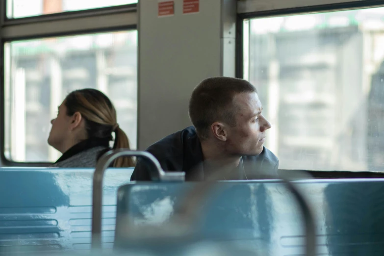 a man and a woman sitting on a bus, by Jaakko Mattila, unsplash, happening, still from the movie, inside the train, ignant, boy staring at the window