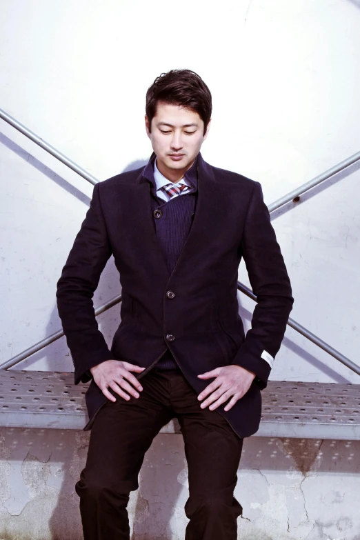 a man in a suit sitting on a bench, an album cover, inspired by Zhou Chen, ethnicity : japanese, full body photograph, yan, stony