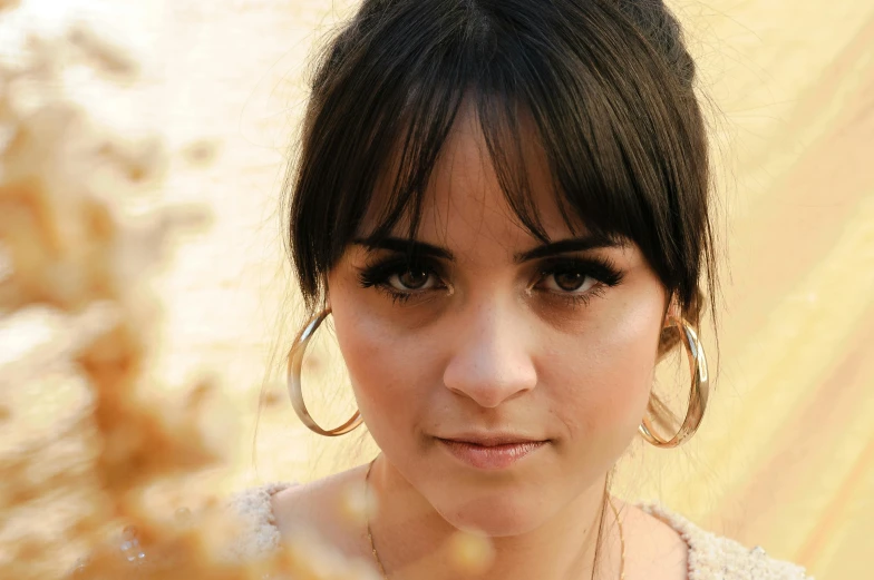 a close up of a person holding a cell phone, an album cover, inspired by Glòria Muñoz, beautiful brown eyes, ana de la reguera portrait, natural lights, whitebangs