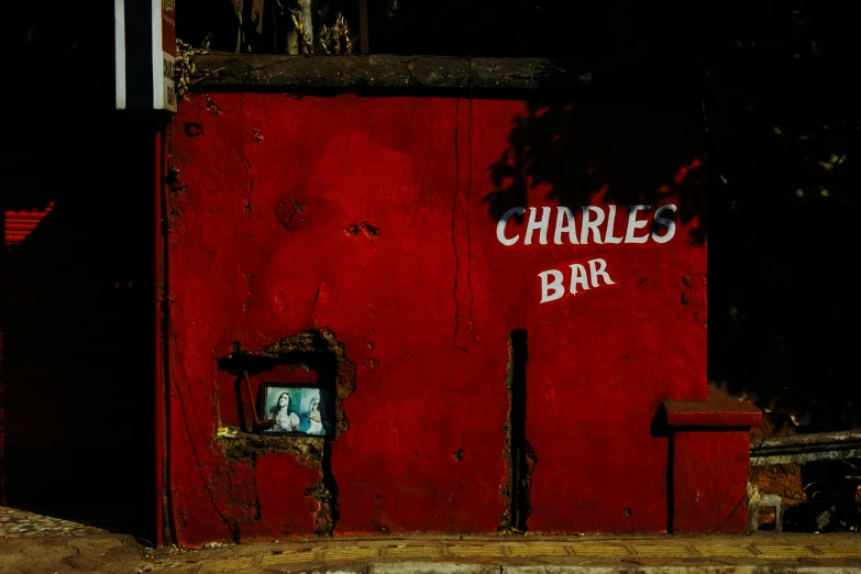 a red building with the word charles's bar painted on it, an album cover, pexels contest winner, chiaroscuro portrait, in chuquicamata, wheres wally, color photograph