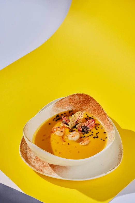 a bowl of soup sitting on top of a yellow table, inspired by Charles Le Roux, very crispy, mango, thumbnail, gourmet