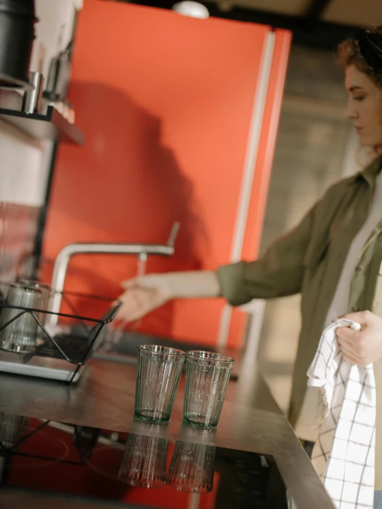 a woman standing in a kitchen preparing food, by Jan Tengnagel, trending on unsplash, happening, glass refraction, thumbnail, low quality photo, espresso machine