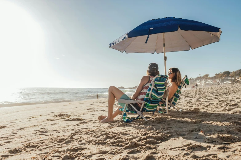 a man and woman sitting under an umbrella on a beach, travel guide, são paulo, avatar image