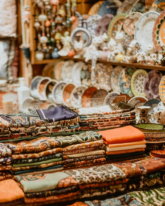 a table topped with lots of plates and napkins, a cross stitch, by Julia Pishtar, trending on pexels, arts and crafts movement, inside an arabian market bazaar, shelves full of medieval goods, thumbnail, multiple stories
