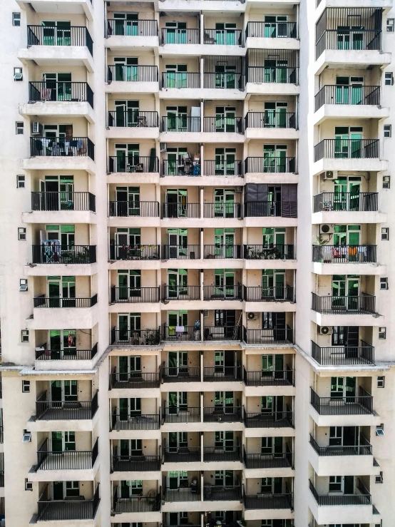 a tall building with lots of windows and balconies, by Benjamin Block, pexels contest winner, black and green scheme, balcony scene, square, 8k 50mm iso 10