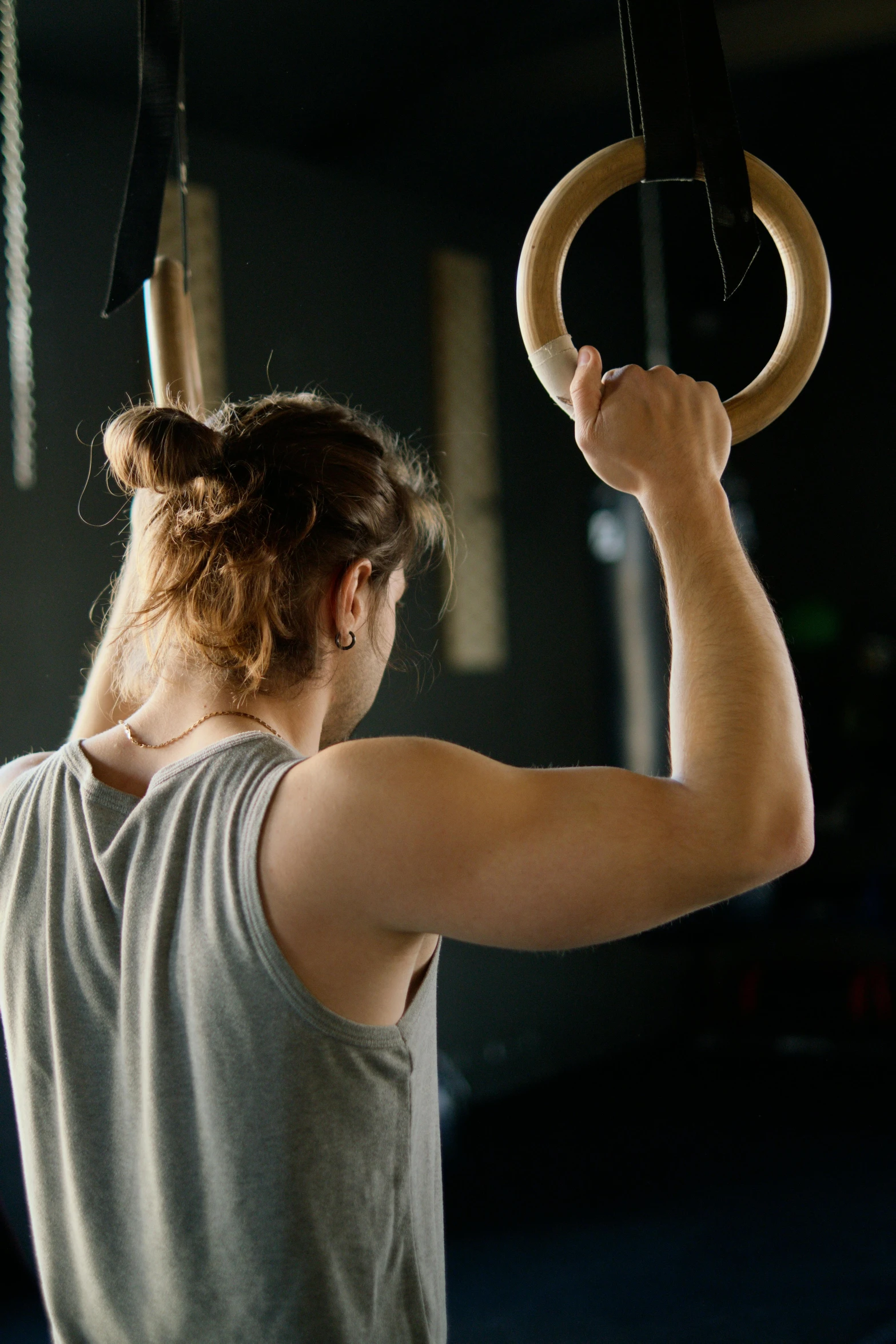 a woman working out on rings in a gym, by Anna Haifisch, trending on pexels, renaissance, from back, male with halo, lachlan bailey, square