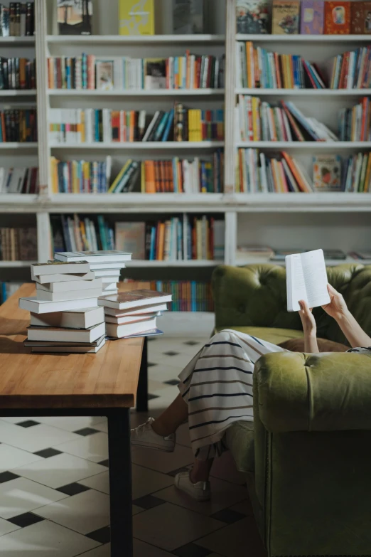 a woman sitting on a couch reading a book, pexels contest winner, maximalism, infinite library, center focus on table, dwell, no - text no - logo