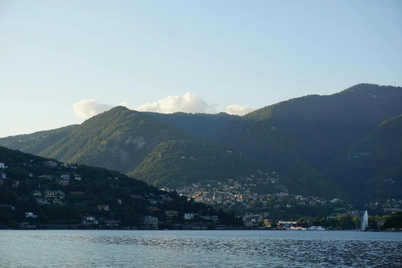 a large body of water with mountains in the background, inspired by Tommaso Redi, pexels contest winner, dappled in evening light, slide show, hillside, viewed from the harbor