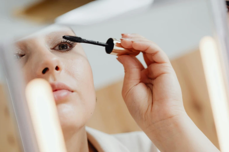 a woman putting on mascara in front of a mirror, pexels contest winner, hurufiyya, delicate and precise brushwork, profile image, black eyeliner, avatar image