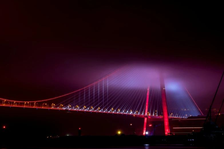 a large bridge that is lit up at night, by Ibrahim Kodra, pexels contest winner, romanticism, red - toned mist, red laser, hull, rgb