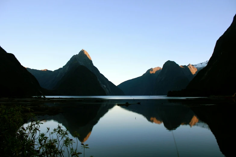 a body of water with mountains in the background, by Peter Churcher, pexels contest winner, hurufiyya, te pae, reflecting light, two mountains in background, 2000s photo