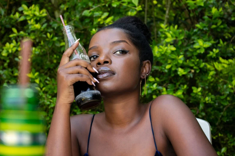 a woman sitting at a table talking on a cell phone, an album cover, inspired by Dorothy Coke, pexels contest winner, photorealism, black skin!!!, anime girl drinks energy drink, 2 4 year old female model, unsplash contest winning photo