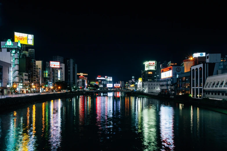 a river running through a city at night, inspired by Kōno Michisei, pexels contest winner, neon signs in the distance, kumamoto, thumbnail, reflection on the water