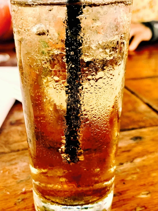 a drink sitting on top of a wooden table, inspired by Dorothy Coke, unsplash, photorealism, with sparkling gems on top, slush!!, low quality photo, dipstick tail